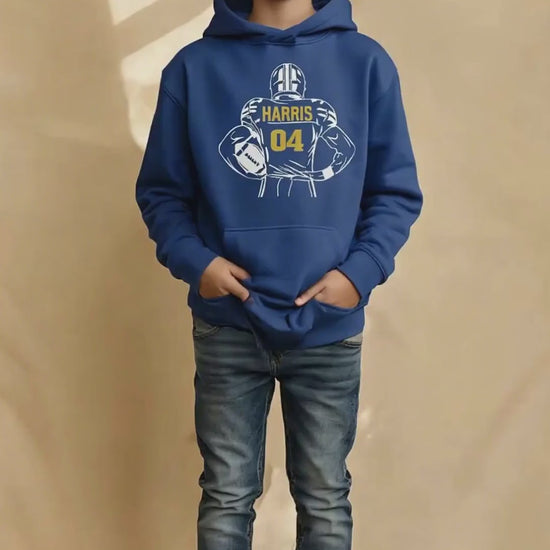 Boy smiling wearing a royal hoodie with a football graphic on it.