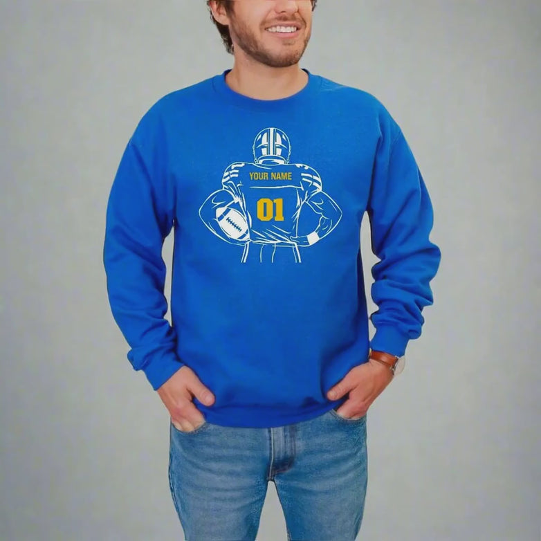 Video of a man wearing a royal crewneck sweatshirt with a customizable football graphic against a white background